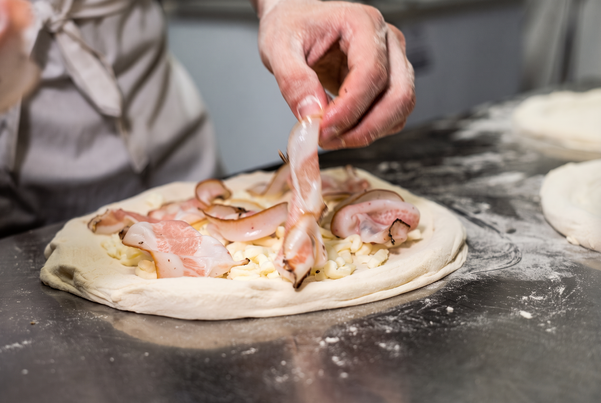 Pizzaiolo de Chifla preparando una pizza con producto italiano